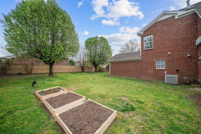 view of yard featuring cooling unit, fence, and a vegetable garden