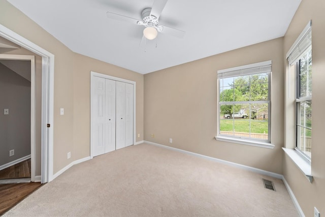 unfurnished bedroom featuring baseboards, a closet, visible vents, and carpet