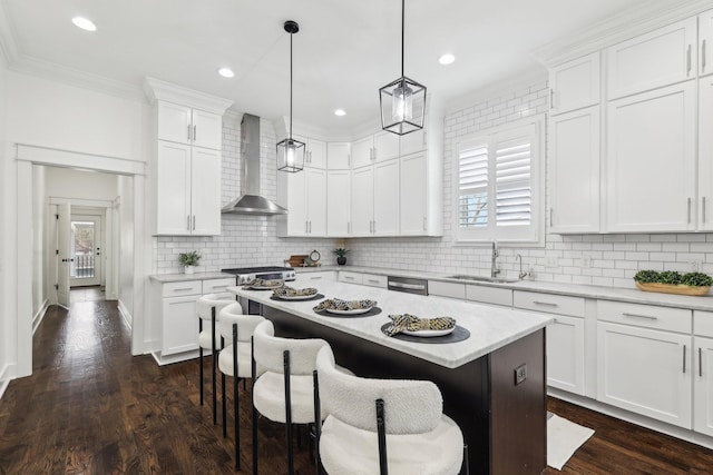 926 Acklen Ave Unit A, Nashville, TN 37203 - kitchen featuring wall chimney range hood, light countertops, white cabinets, a kitchen bar, and a sink
