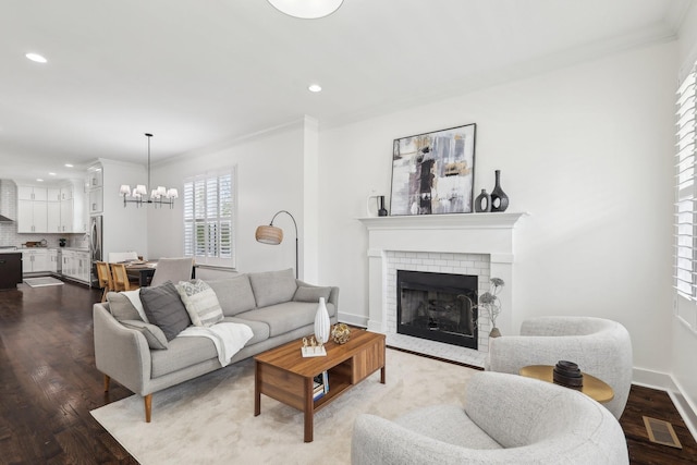 926 Acklen Ave Unit A, Nashville, TN 37203 - living room with ornamental molding, a notable chandelier, a brick fireplace, and dark wood-style floors