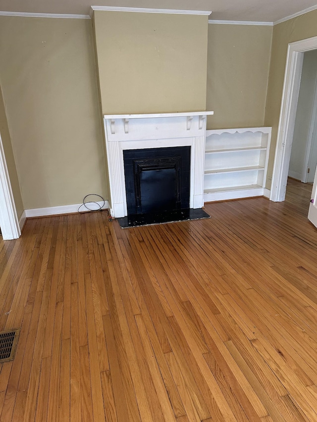 309 3rd Ave Unit 40, Fayetteville, TN 37334 - unfurnished living room featuring baseboards, crown molding, a fireplace with flush hearth, visible vents, and wood-type flooring