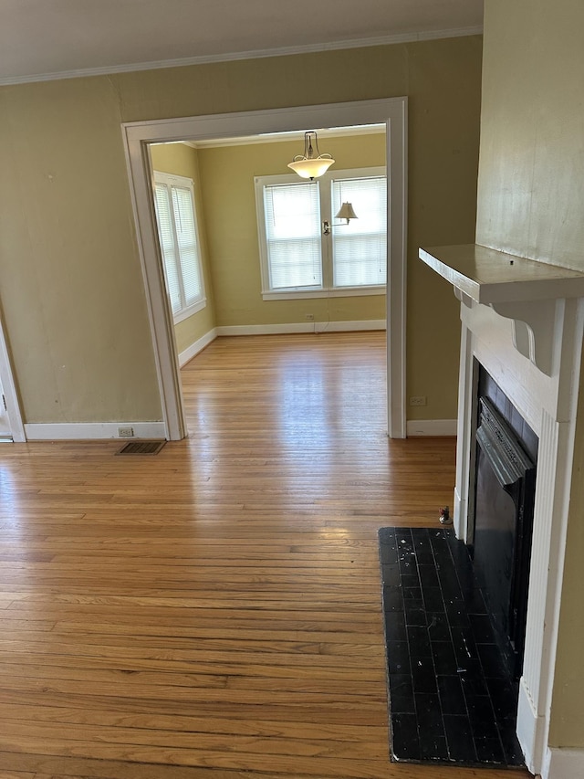 309 3rd Ave Unit 40, Fayetteville, TN 37334 - unfurnished living room with visible vents, baseboards, a tiled fireplace, ornamental molding, and light wood-style floors