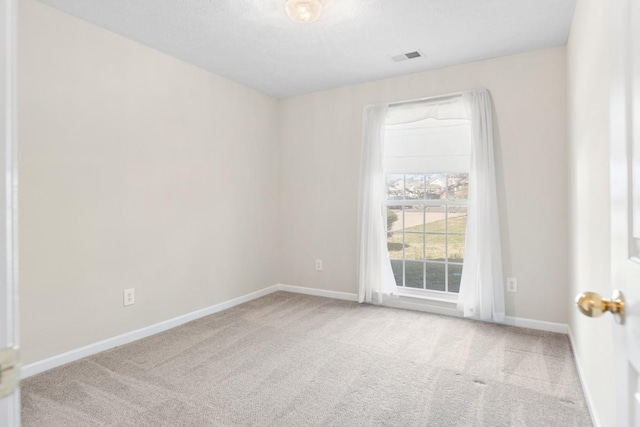 carpeted empty room with visible vents and baseboards
