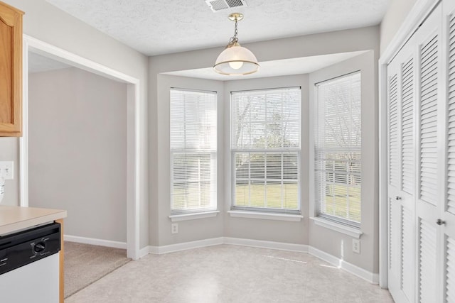 unfurnished dining area featuring visible vents, baseboards, and a textured ceiling