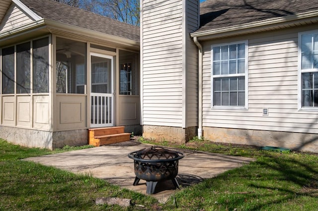 exterior space with a sunroom, a patio, a fire pit, a chimney, and a shingled roof