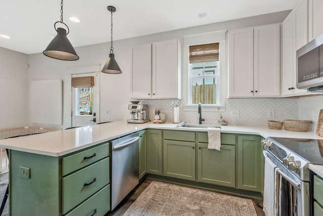 kitchen featuring green cabinets, stainless steel appliances, a sink, and recessed lighting