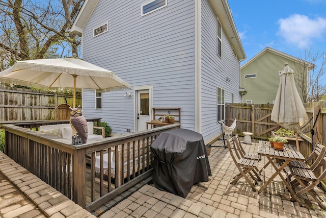 rear view of property with outdoor dining area, a fenced backyard, and a patio
