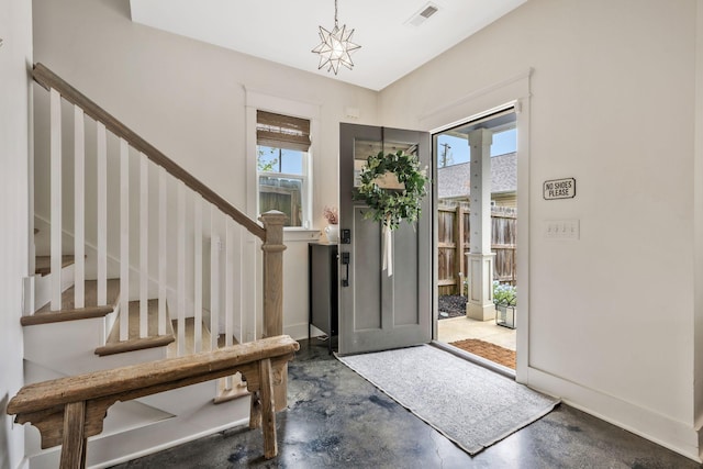 foyer entrance featuring concrete floors and stairs