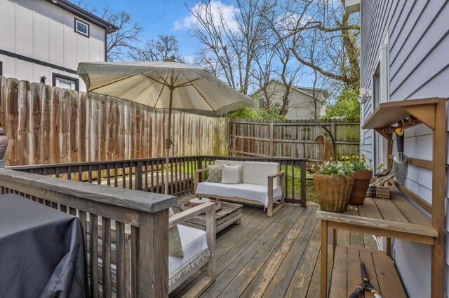 wooden terrace featuring a fenced backyard and an outdoor living space