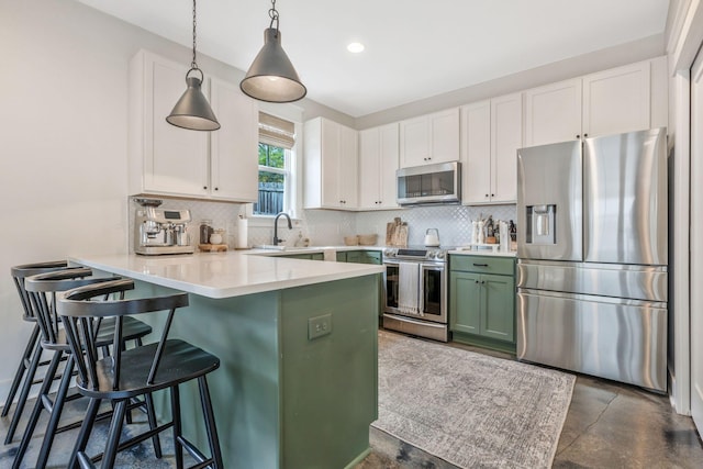 kitchen featuring stainless steel appliances, a peninsula, white cabinetry, tasteful backsplash, and recessed lighting