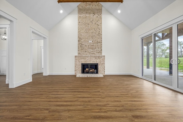 unfurnished living room with high vaulted ceiling, baseboards, dark wood finished floors, and a fireplace