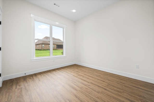 spare room featuring wood finished floors, baseboards, and recessed lighting
