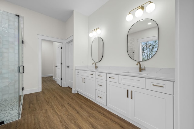 bathroom featuring a sink, baseboards, a stall shower, and wood finished floors