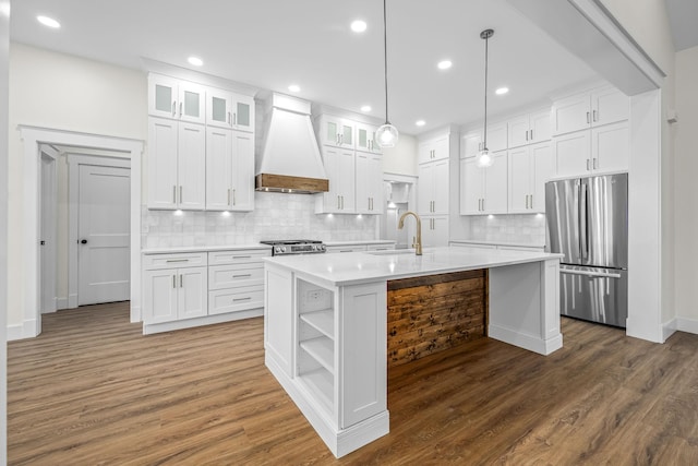 kitchen featuring open shelves, a sink, light countertops, freestanding refrigerator, and premium range hood