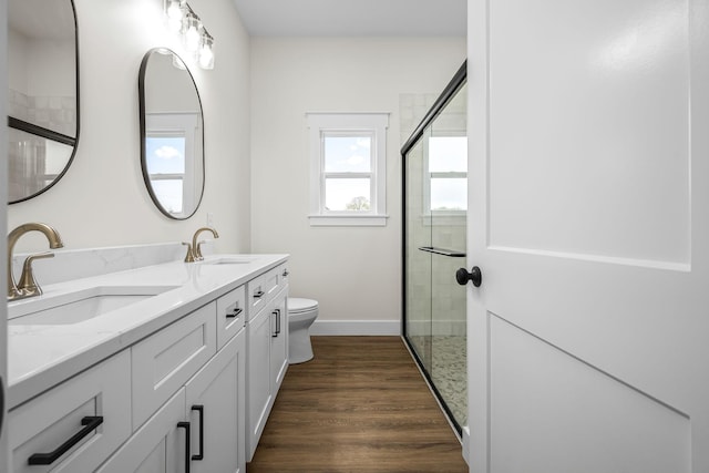 bathroom with a sink, a stall shower, and wood finished floors