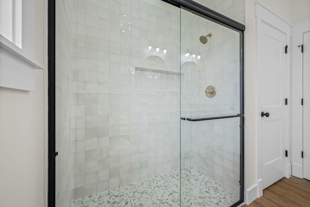 bathroom with a stall shower and wood finished floors
