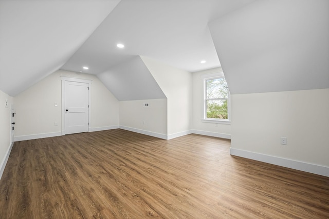 bonus room featuring baseboards, recessed lighting, vaulted ceiling, and wood finished floors