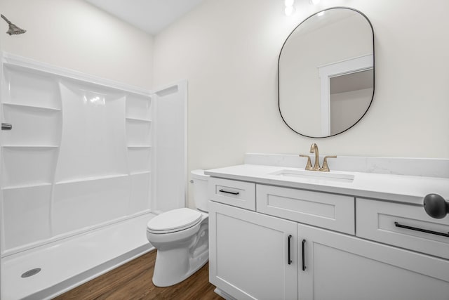 full bath with a shower, wood finished floors, vanity, and toilet
