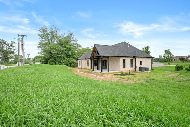 102 Victoria Ct N, Tullahoma, TN 37388 - rear view of house featuring cooling unit, roof with shingles, a yard, and brick siding