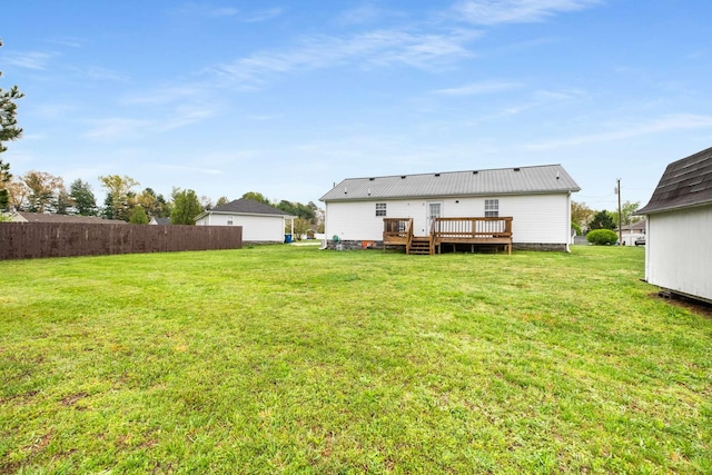 rear view of property featuring a yard and a wooden deck