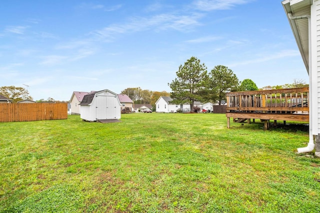 view of yard featuring an outbuilding, fence, and a storage unit