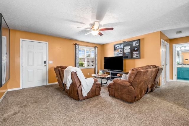 carpeted living room with a textured ceiling, baseboards, and a ceiling fan