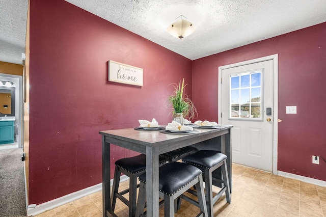 dining area with baseboards and a textured ceiling