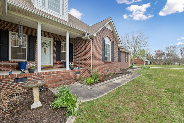 view of side of property featuring a yard, covered porch, crawl space, brick siding, and roof with shingles