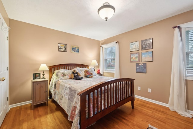 bedroom with wood finished floors and baseboards