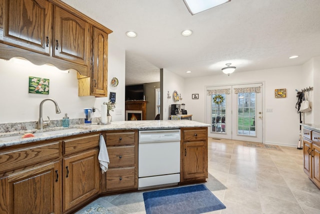 kitchen with recessed lighting, white dishwasher, brown cabinetry, and a peninsula