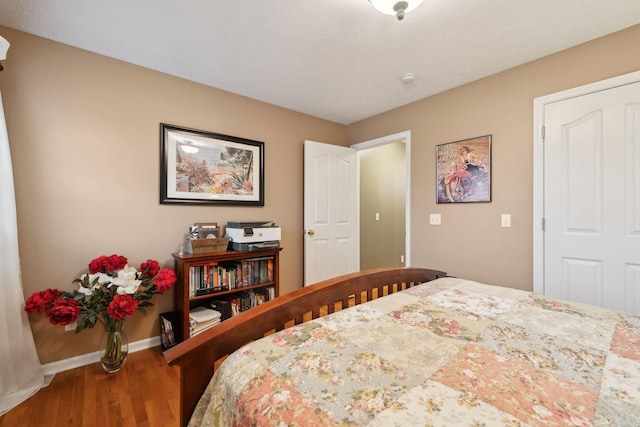 bedroom with baseboards and wood finished floors