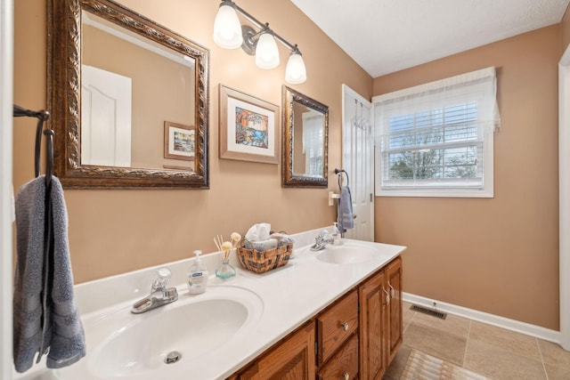 full bathroom featuring baseboards, double vanity, a sink, and visible vents