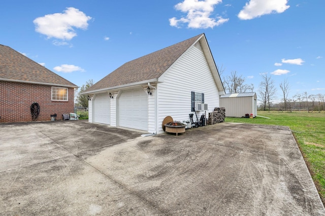 view of home's exterior featuring a yard, a detached garage, an outdoor structure, and cooling unit