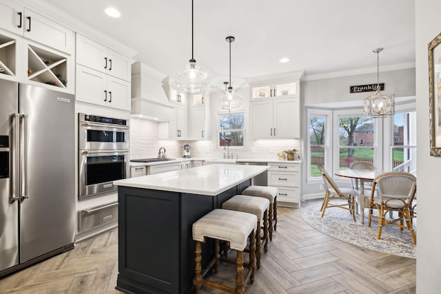 2009 Cedarmont Dr, Franklin, TN 37067 - kitchen with ornamental molding, light countertops, a warming drawer, backsplash, and stainless steel appliances