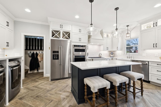 2009 Cedarmont Dr, Franklin, TN 37067 - kitchen featuring crown molding, washing machine and clothes dryer, backsplash, and stainless steel appliances