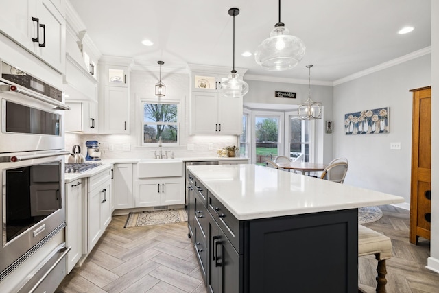 2009 Cedarmont Dr, Franklin, TN 37067 - kitchen with crown molding, appliances with stainless steel finishes, white cabinetry, and a kitchen breakfast bar