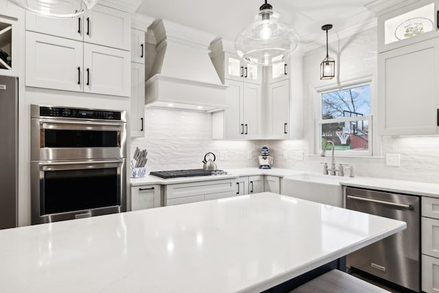 2009 Cedarmont Dr, Franklin, TN 37067 - kitchen with tasteful backsplash, premium range hood, light countertops, decorative light fixtures, and appliances with stainless steel finishes