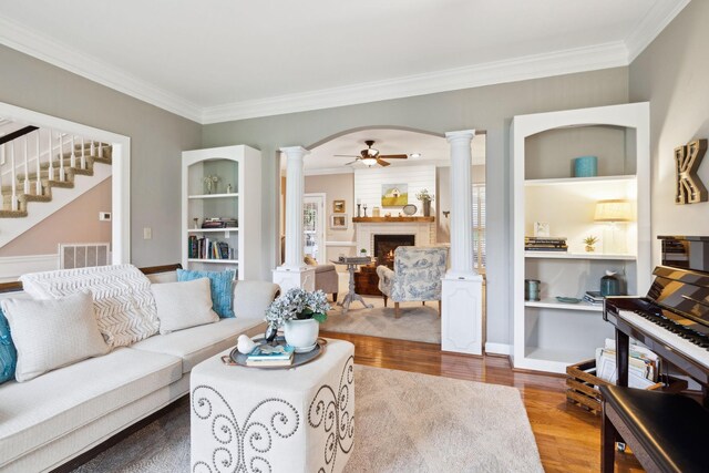 2009 Cedarmont Dr, Franklin, TN 37067 - living room featuring visible vents, a brick fireplace, ornate columns, stairway, and wood finished floors