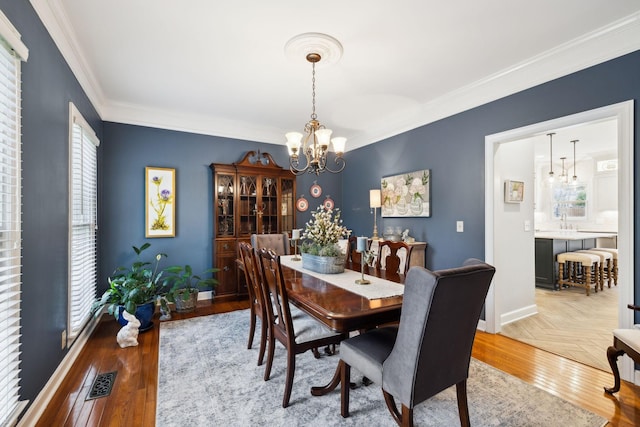 2009 Cedarmont Dr, Franklin, TN 37067 - dining room with crown molding, visible vents, light wood finished floors, a notable chandelier, and baseboards