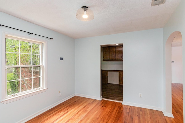 740 Kleeman Dr, Clarksville, TN 37040 - empty room with arched walkways, light wood-style flooring, visible vents, and baseboards