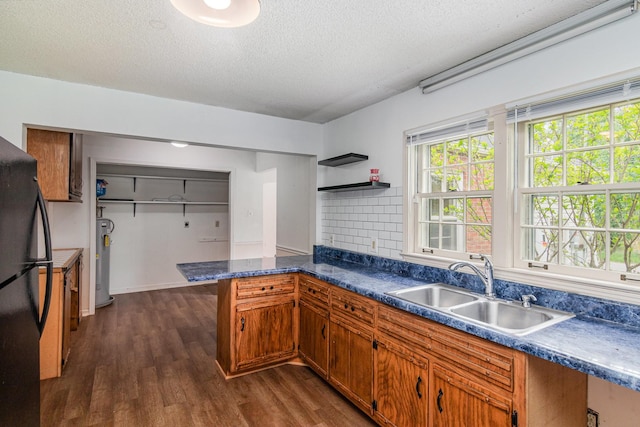 740 Kleeman Dr, Clarksville, TN 37040 - kitchen with water heater, a sink, freestanding refrigerator, a peninsula, and brown cabinetry