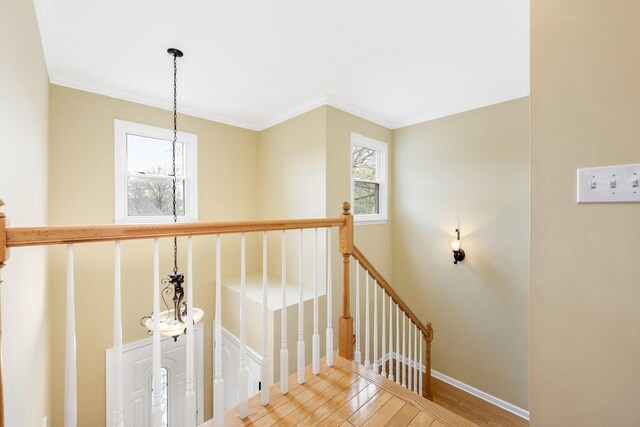 stairs featuring ornamental molding, baseboards, an inviting chandelier, and wood finished floors