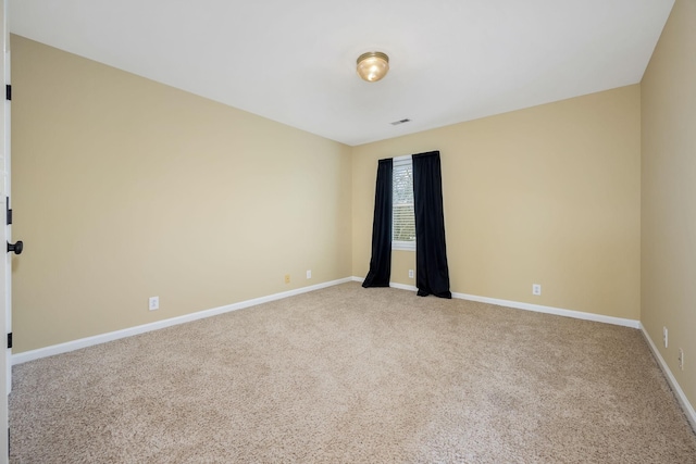 empty room with visible vents, baseboards, and light carpet