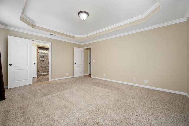 unfurnished bedroom featuring baseboards, ornamental molding, carpet flooring, visible vents, and a tray ceiling