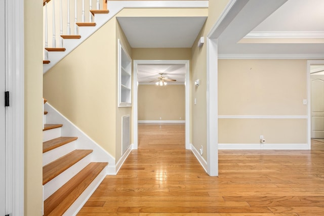 foyer entrance featuring stairway, crown molding, visible vents, ceiling fan, and hardwood / wood-style flooring