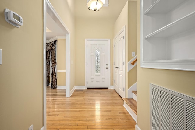 foyer with visible vents, baseboards, and light wood finished floors