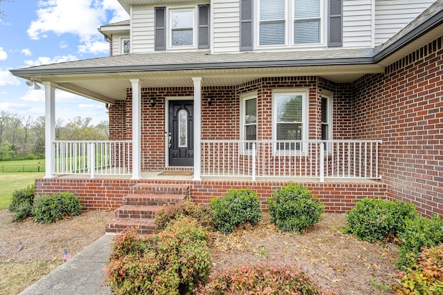 property entrance with brick siding and covered porch