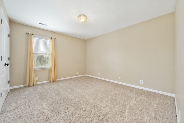carpeted spare room with visible vents and baseboards