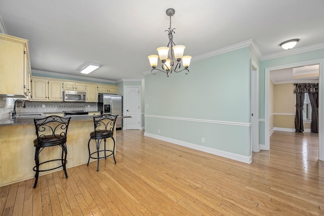 kitchen with tasteful backsplash, a sink, appliances with stainless steel finishes, a chandelier, and a peninsula