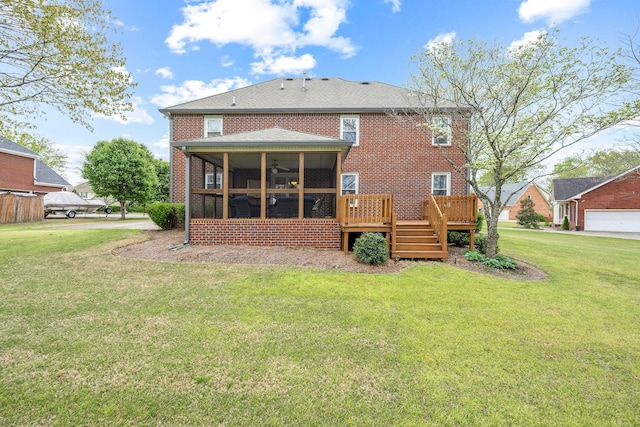 back of property featuring a sunroom, a yard, a deck, and brick siding